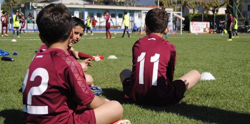 Young footballers resting on the grass at the Pisa World Cup football tournament