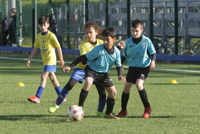 Unga fotbollsspelare i gula och turkosblå tröjor spelar i Trofeo Città di Viareggio-turneringen