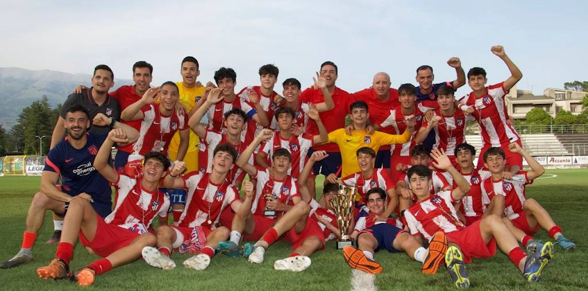 Cheerful soccer team celebrating with a trophy on the field