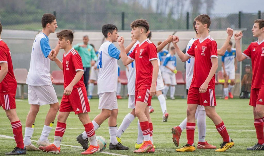 Ungdomsfotbollslag hälsar på varandra efter match i Lazio Cup