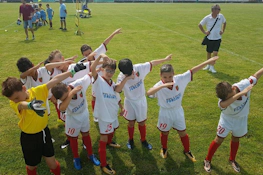 युवा फ़ुटबॉल टीम हरी पिच पर जीत का जश्न मना रही है