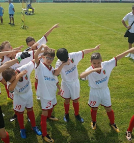 青少年のサッカーチームが緑のピッチで勝利を祝う