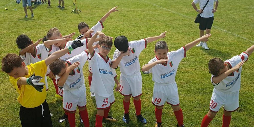 Unga fotbollsspelare firar en seger på en grön plan