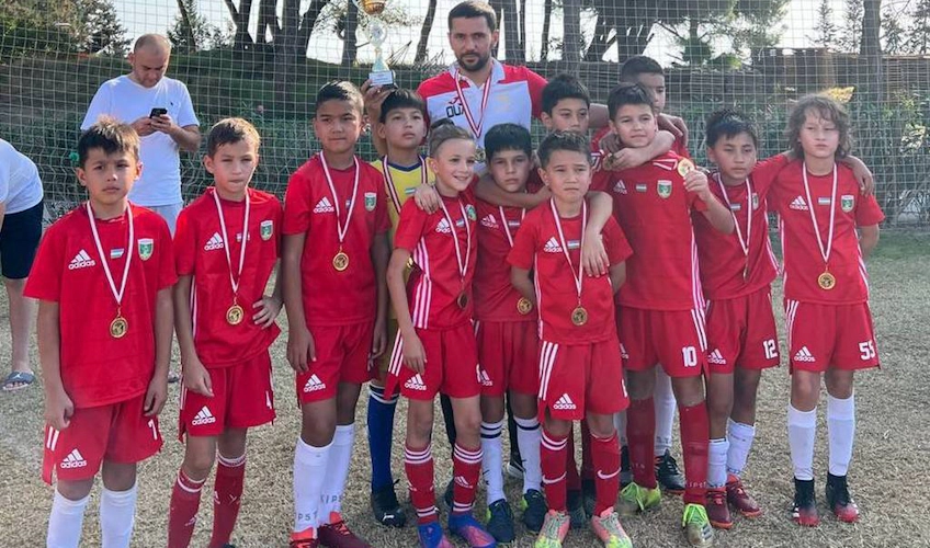 فريق كرة القدم الشبابي بالزي الأحمر مع ميداليات في كأس الربيع أنطاليا