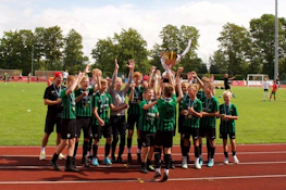 Nuorten jalkapallojoukkue juhlii voittoa pokaalin kanssa Tarton turnauksessa