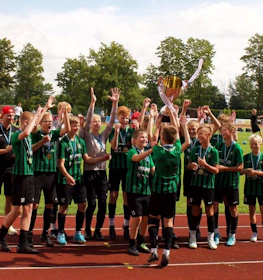 Młodzieżowa drużyna piłkarska świętuje zwycięstwo z pucharem na turnieju w Tartu