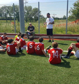 Valmentaja opettaa nuoria jalkapalloilijoita Riviera Summer Cup -turnauksessa
