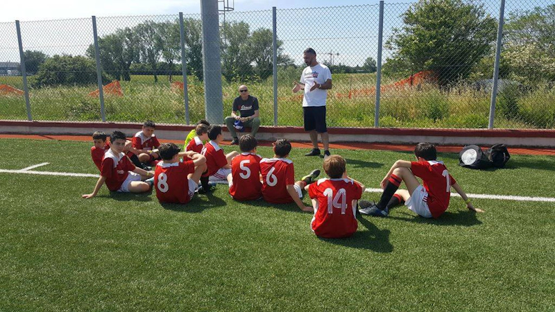 Trener lærer opp unge fotballspillere på Riviera Summer Cup-turneringen