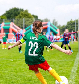 Number 22 female soccer player in green jersey making a shot at the Laola Cup tournament