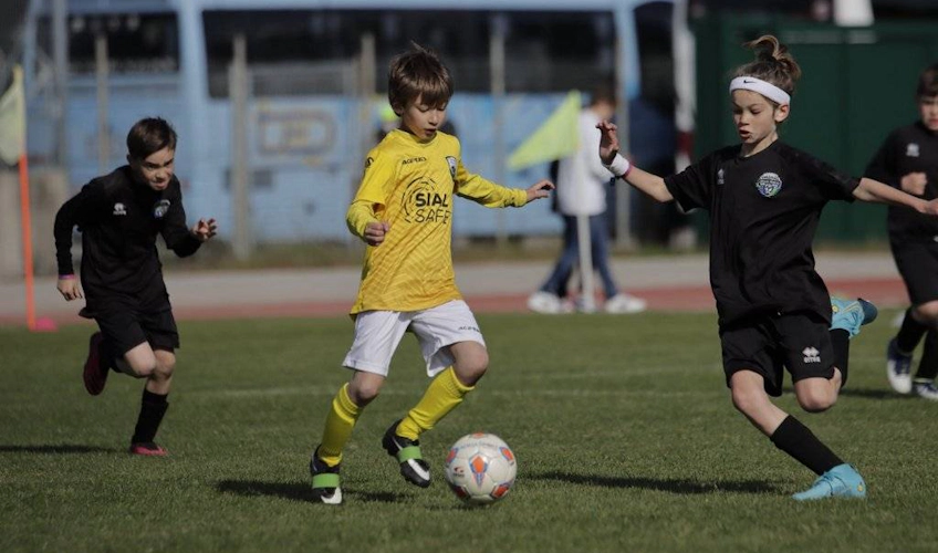 Young football players in yellow and black uniforms playing at the Trofeo Riviera football tournament