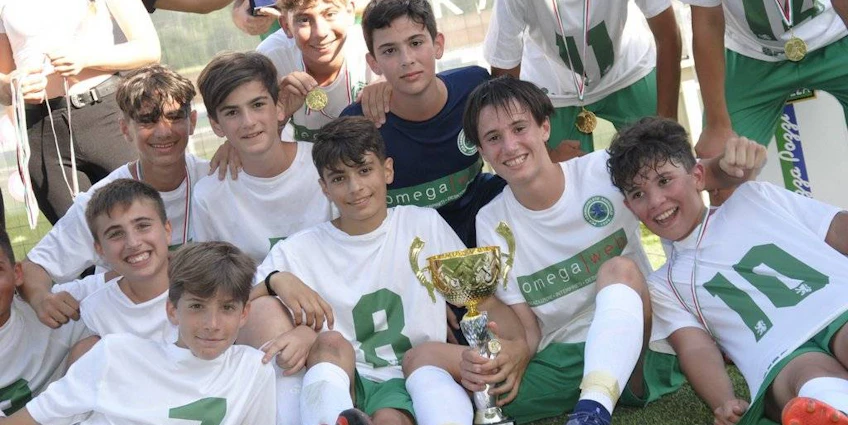 Versiliaカップでトロフィーを持つ若いサッカー選手。