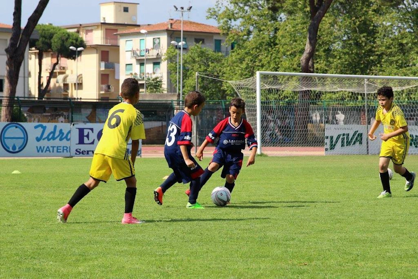 Children in football kits playing at the Versilia Cup tournament