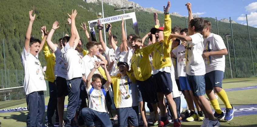 Dzieci świętujące zwycięstwo na festiwalu piłkarskim Val di Fassa.
