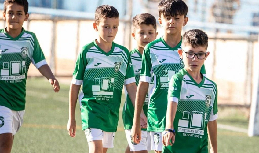 Tineri jucători în echipament verde la turneul de fotbal Spain Esei Cup.