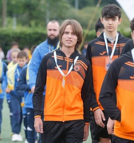 Unge fodboldspillere i orange-sorte træningssæt ved Xixón Esei Cup