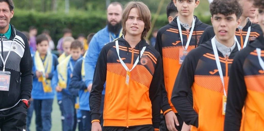 Xixón Esei Cup 토너먼트에서 오렌지-검은 트랙수트를 입은 젊은 축구 선수들