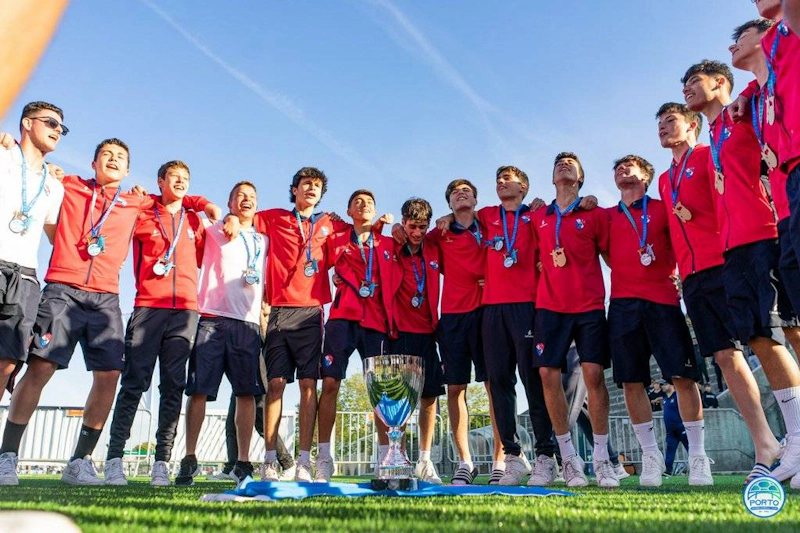 Equipo de fútbol juvenil con medallas en el torneo Porto International Cup