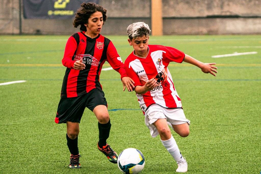 Two young soccer players vying for the ball at the Porto International Cup tournament