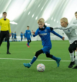 Kinder in Sportbekleidung spielen Fußball beim iSport February Cup Turnier