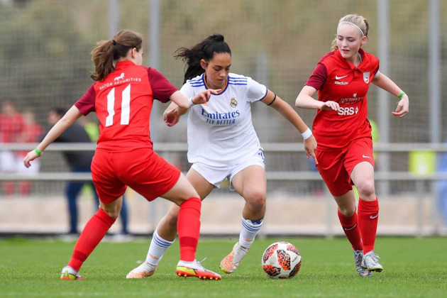 Kvinnelige fotballag i rødt og hvitt spiller på Costa Daurada Easter Cup-turneringen
