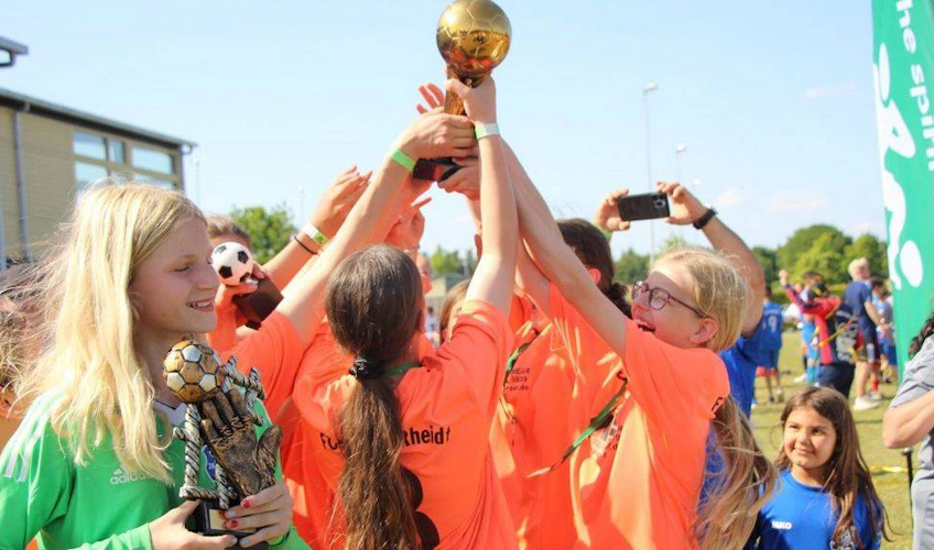 लड़कियाँ फुटबॉल त्योहार में जीत का जश्न मना रही हैं