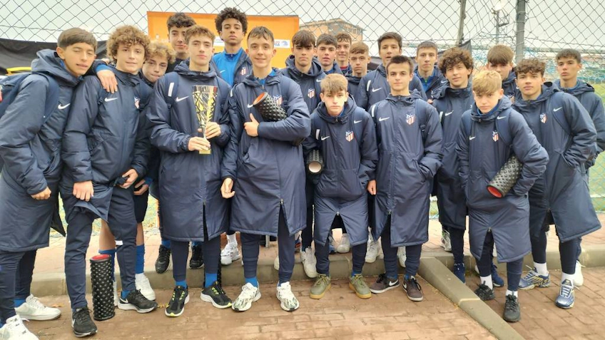 Team of teenagers with a trophy at the Esei Madrid Elite Cup football tournament.
