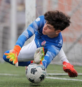 Goalkeeper in blue jersey making a save at the FIT 24 Summer Edition soccer tournament in the United States