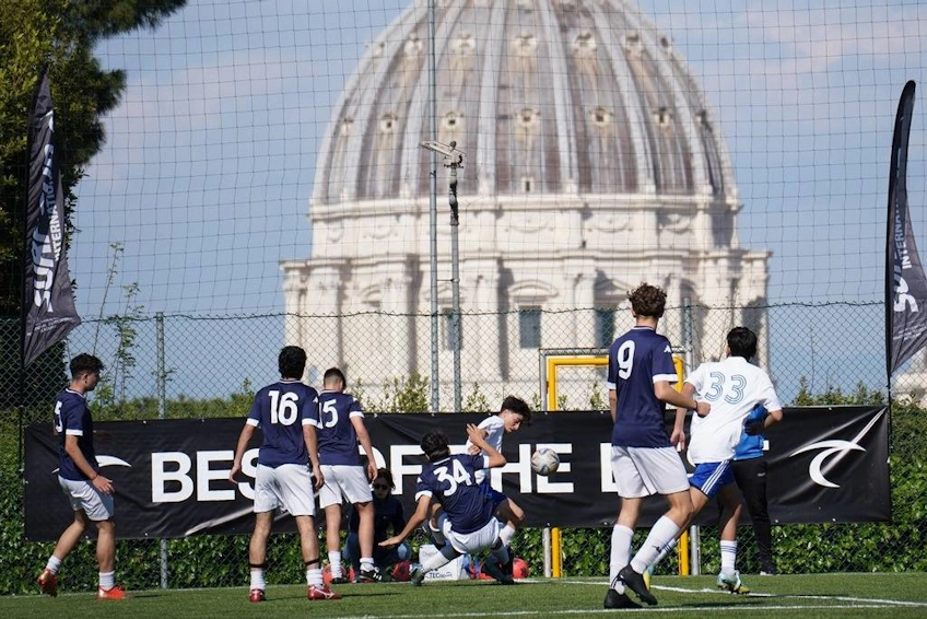 Nuoret jalkapalloilijat Surf Cup -turnauksessa Roomassa, kupoli taustalla.