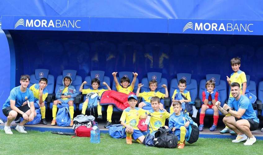 Equipe de futebol juvenil sentada no estádio Copa Andorra
