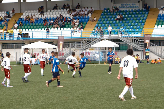 ट्रोफियो मार तिर्रेनो टूर्नामेंट में युवा फुटबॉल मैच, खिलाड़ी मैदान पर वर्दी में