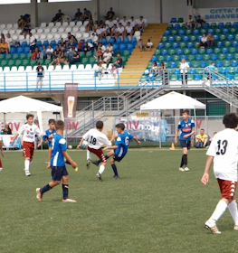 Youth soccer game at Trofeo Mar Tirreno tournament, players in jerseys on the pitch