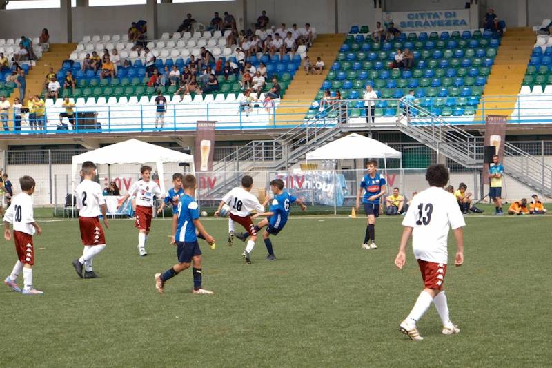 Youth football match at Trofeo Mar Tirreno tournament, players in uniform on the field