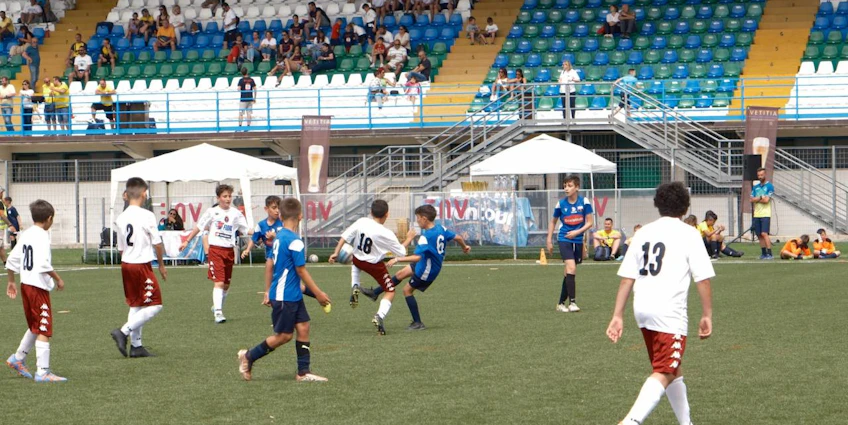 Youth soccer game at Trofeo Mar Tirreno tournament, players in jerseys on the pitch