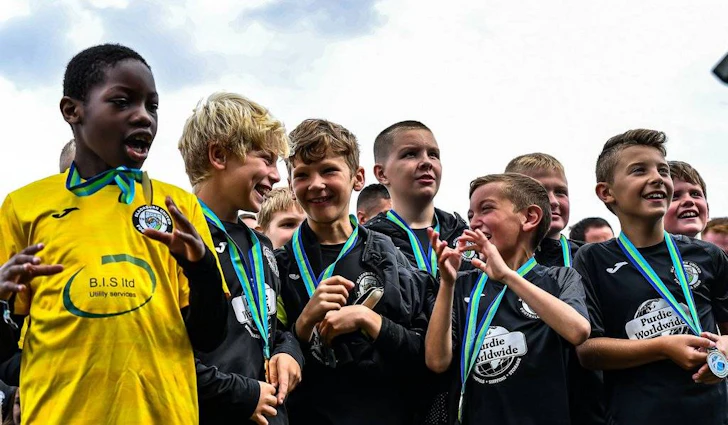 에딘버러 컵 축구 대회에서 메달을 획득한 어린 축구 선수들