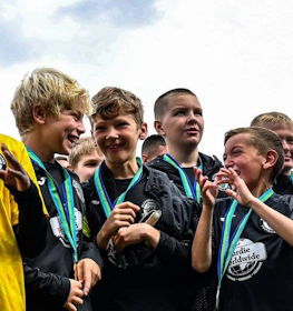 Unga fotbollsspelare med medaljer på The Edinburgh Cup fotbollsturnering