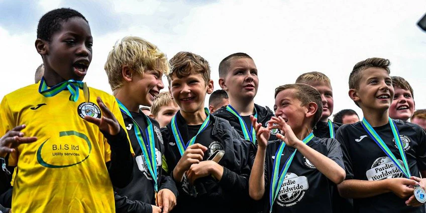 Unga fotbollsspelare med medaljer på The Edinburgh Cup fotbollsturnering