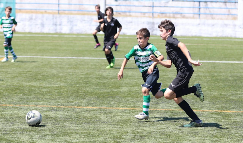 Jovens futebolistas de uniforme preto e verde na Copa Miranda