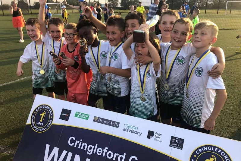 青少年足球队在Cringleford杯赛获胜庆祝。
