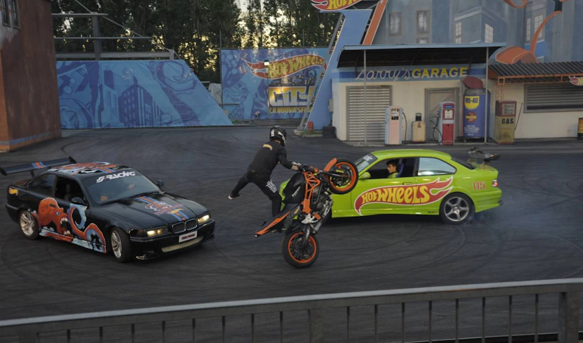 Acrobacias de motocicleta e drifting de carro em espetáculo de parque de diversões