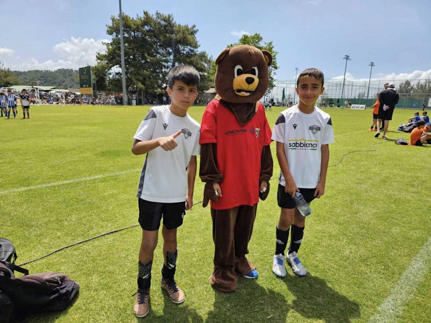 Ungdomsfotbollsspelare med maskot på Platres Summer fotbollsturnering