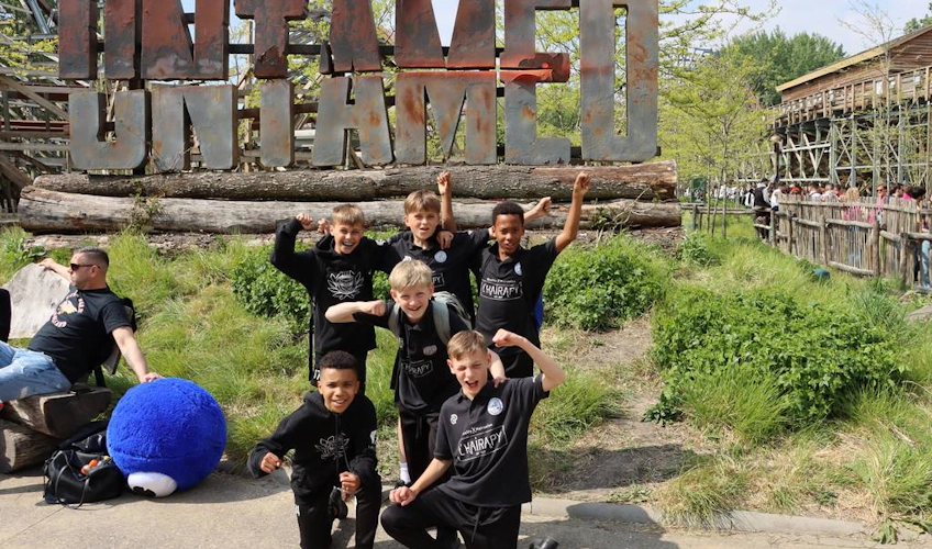 Dziecięca drużyna piłkarska przed znakiem 'UNTAMED' na turnieju Walibi Cup w maju