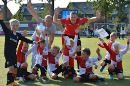 जून में वालिबी कप फुटबॉल टूर्नामेंट में ट्रॉफी के साथ बच्चों की फुटबॉल टीम