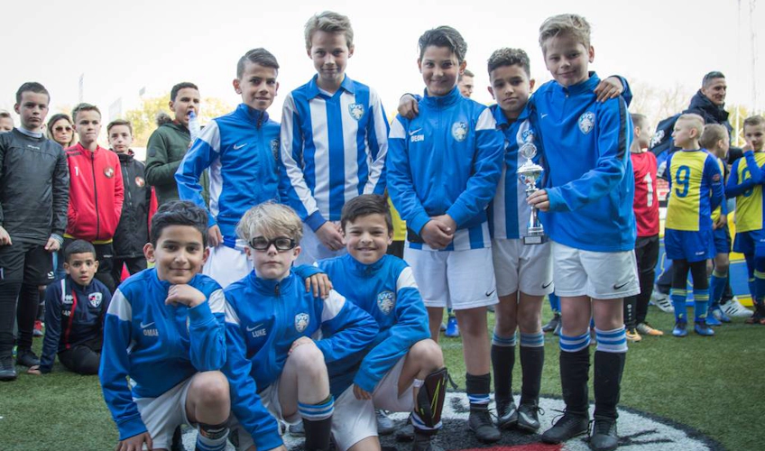 Equipe de futebol juvenil com troféu no torneio Limburgse Peel Cup