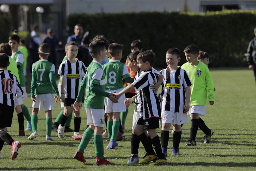 Echipe de fotbal pentru tineret se salută după joc.