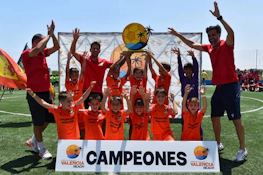 청소년 축구팀이 'Campeones' 배너와 함께 발렌시아 비치 토너먼트에서 승리를 축하합니다.