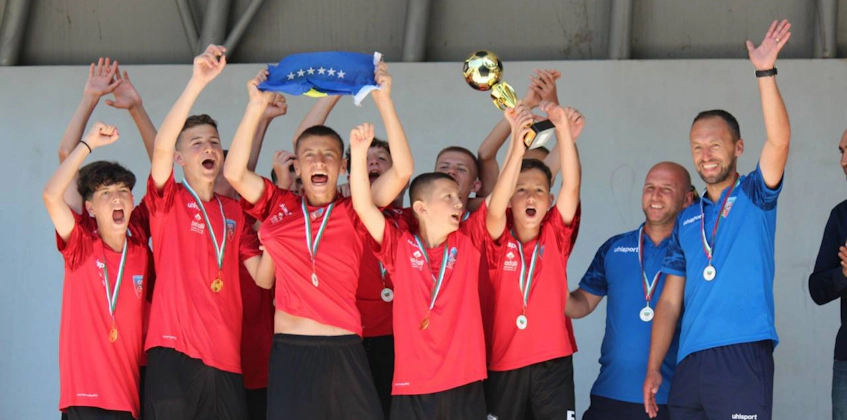 身穿红衬衫的年轻足球运动员庆祝赛事胜利
