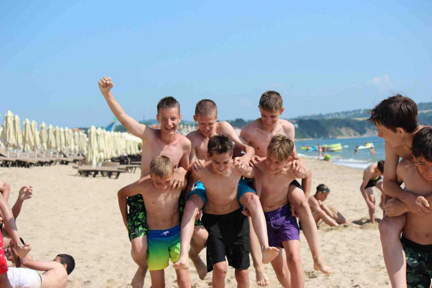 Unga spelare njuter av en stranddag under pausen mellan South Sea Cup-matcher