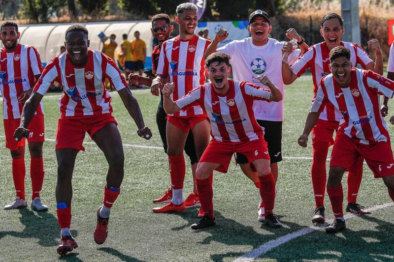 Rühm jalgpallureid punavalges triibulises vormis tähistab võitu väljakul