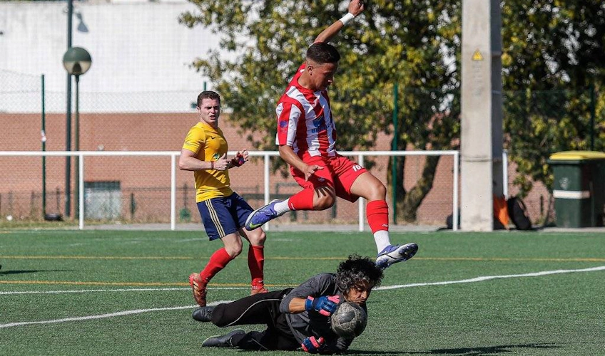 Jugador de fútbol saltando sobre el portero en un partido de la Portugal Summer Cup