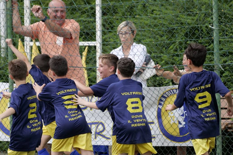 Unga fotbollsspelare och tränare firar seger på Festival Scuole Calcio Mirabilandia-turneringen